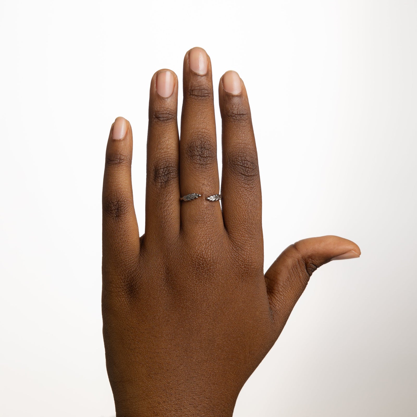The silver Palestine Olive leaf ring V2 worn on a model's finger, showcasing the olive leaf design.