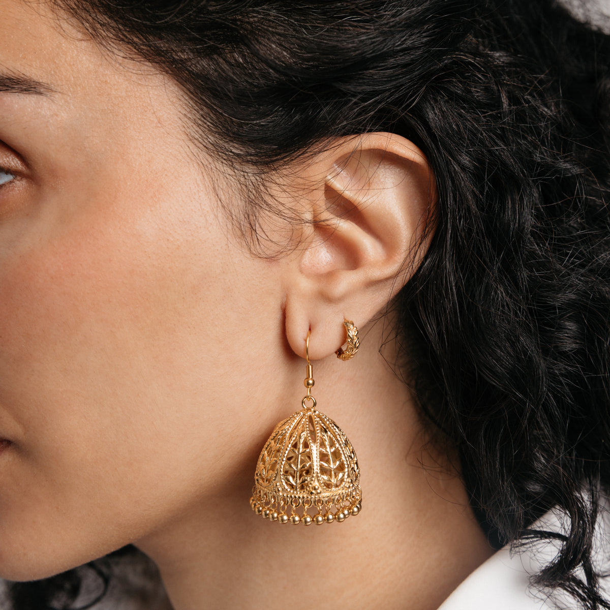 Model styled in 18k gold-plated Nominal jewelry featuring an ear stack with the Olive Branch Jhumka Earrings and Palestinian Olive Huggie Hoops.