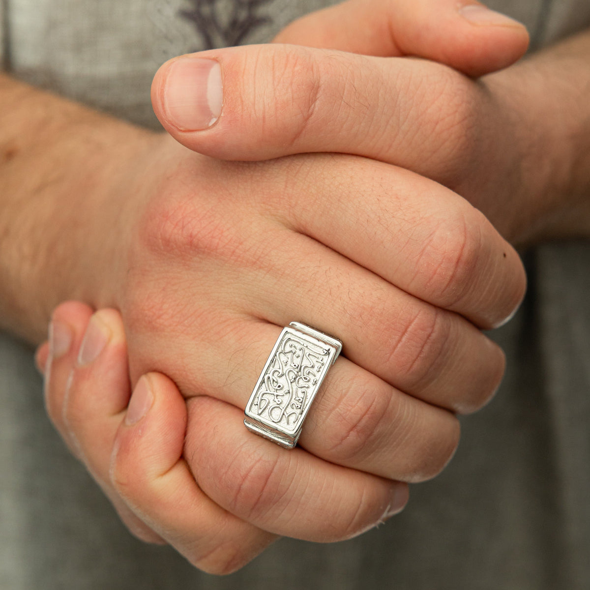 Photo of the model's clasped hands wearing the Our Roots Run Deep Ring | Men on their right ring finger.