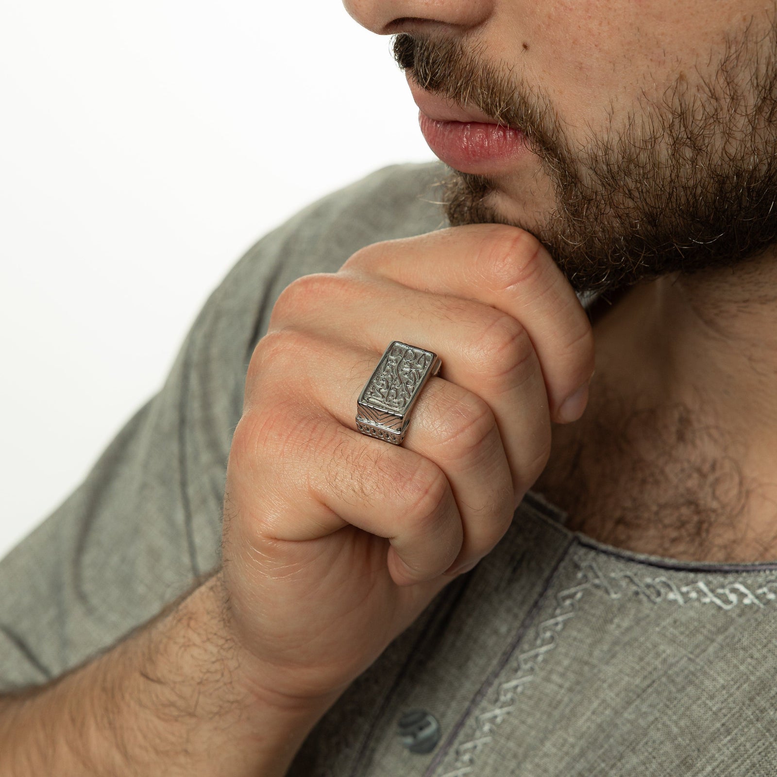 Model touching their chin with their right hand, wearing the silver ring on the ring finger.