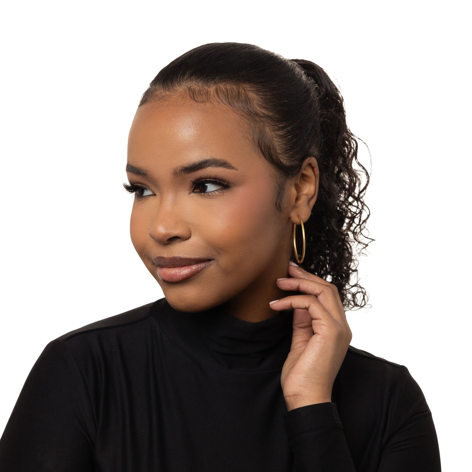 Photo of the model wearing the gold Oversized Essential Hoops | 40mm on their left ear.
