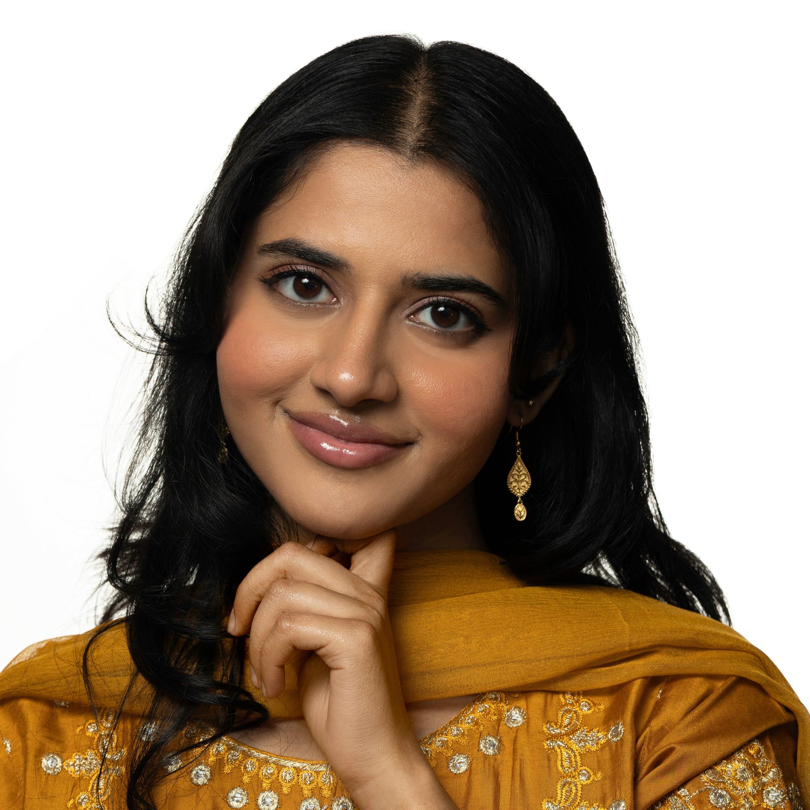 Photo of the model smiling at the camera. The model is wearing the gold Paisley Garden Earrings.