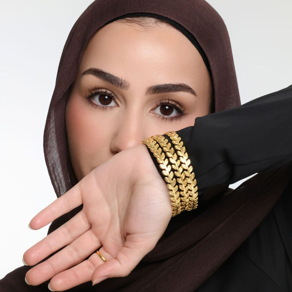Close up of gold Palestine Olive Layering Bangles as worn by the model on their left hand.