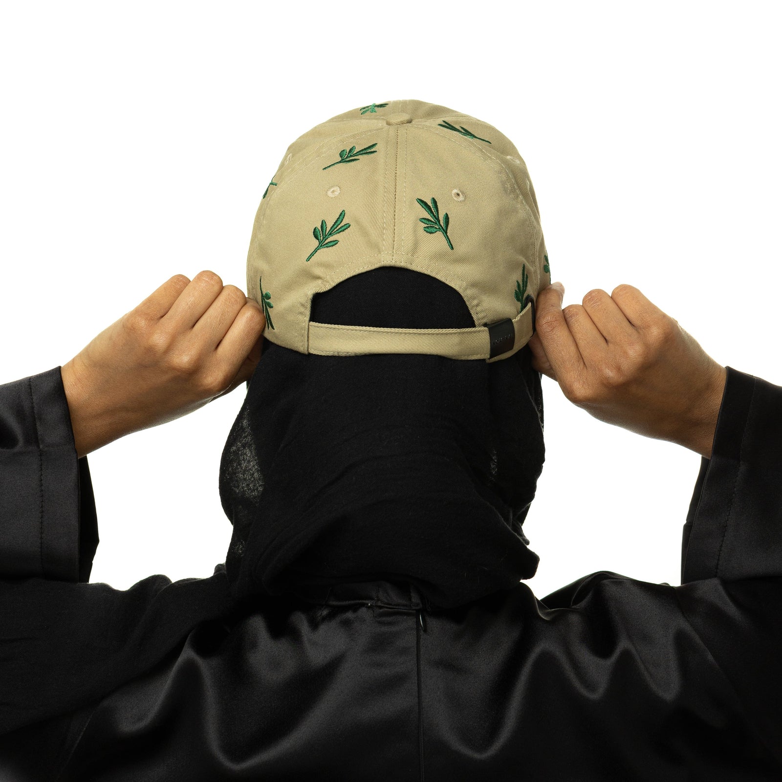 Photo of the back profile of the cap as worn and held by the model.