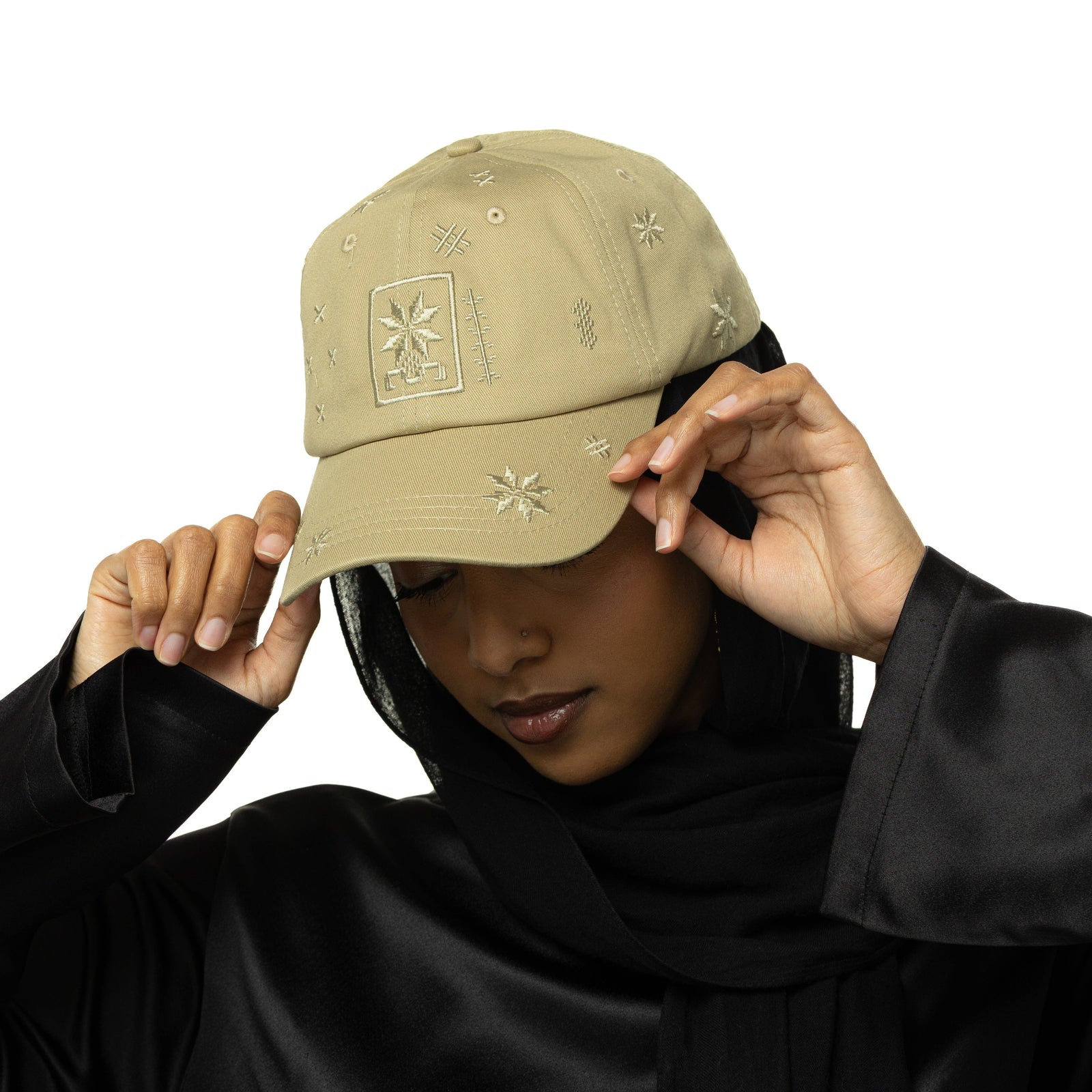 Photo of the model wearing the Palestinian Tatreez Hat while looking down.