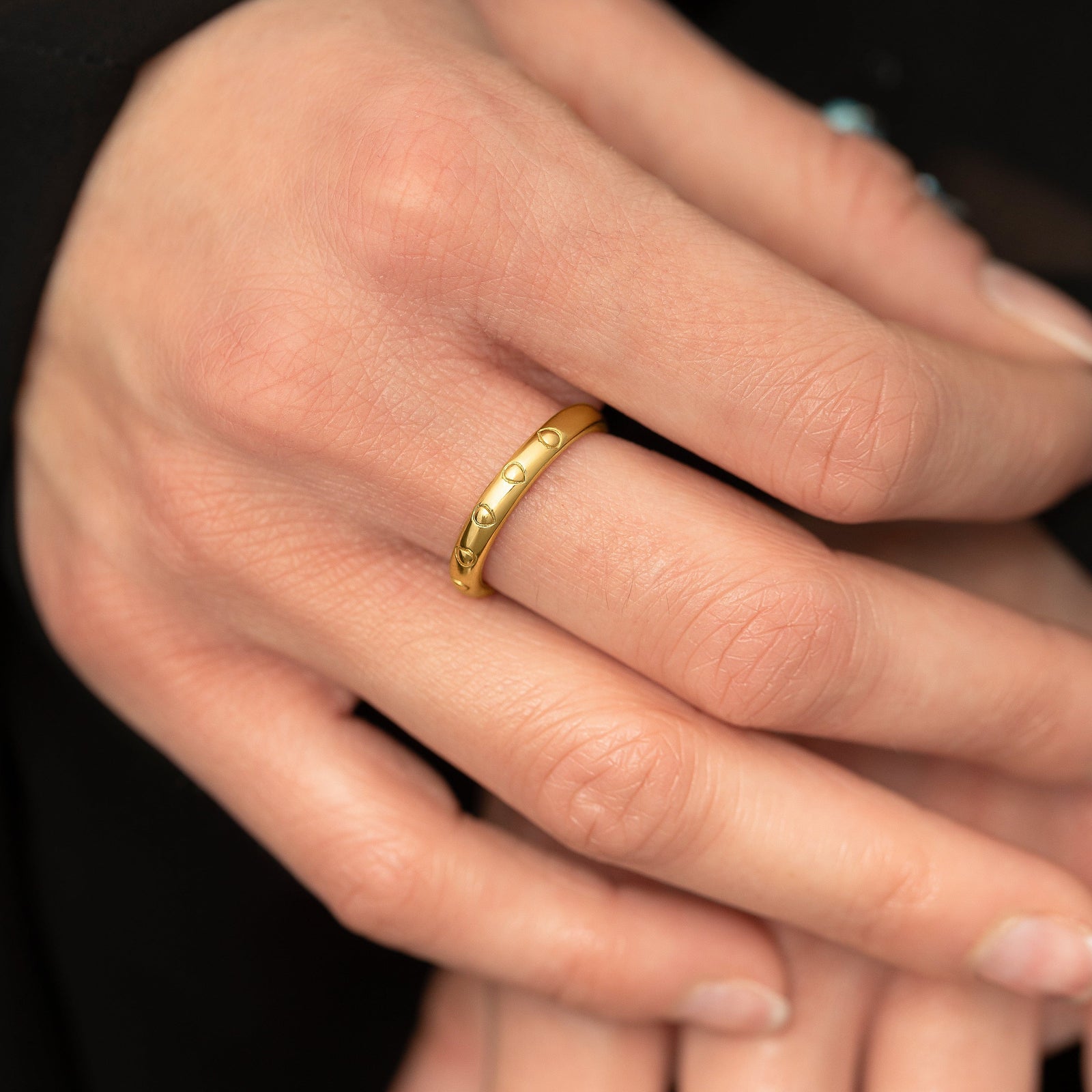 Close up of the model's right hand focusing on the gold Palestinian Watermelon Seed Ring worn on their right middle finger.