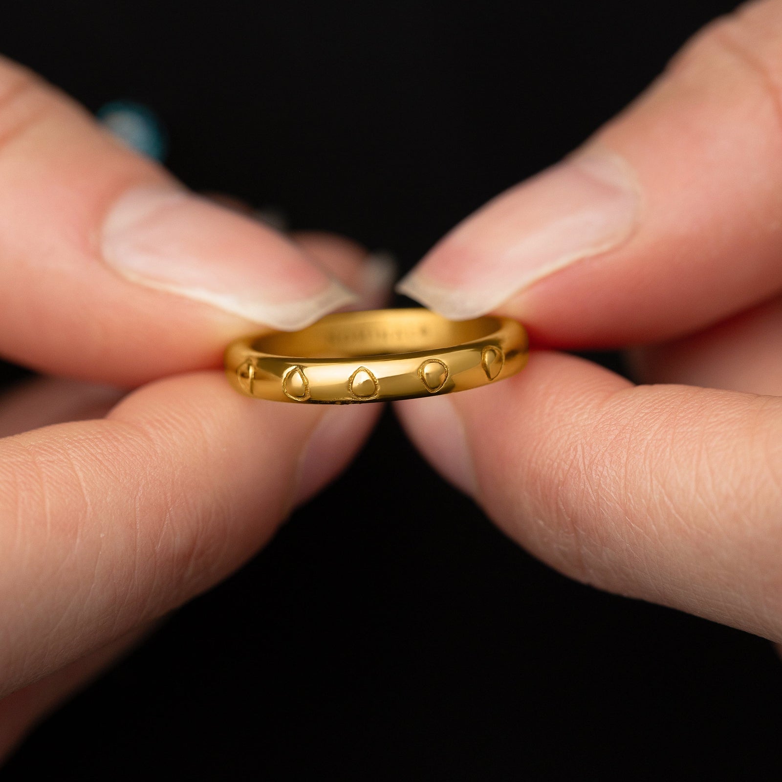 Model holds the gold Palestinian Watermelon Seed Ring to show its design. 