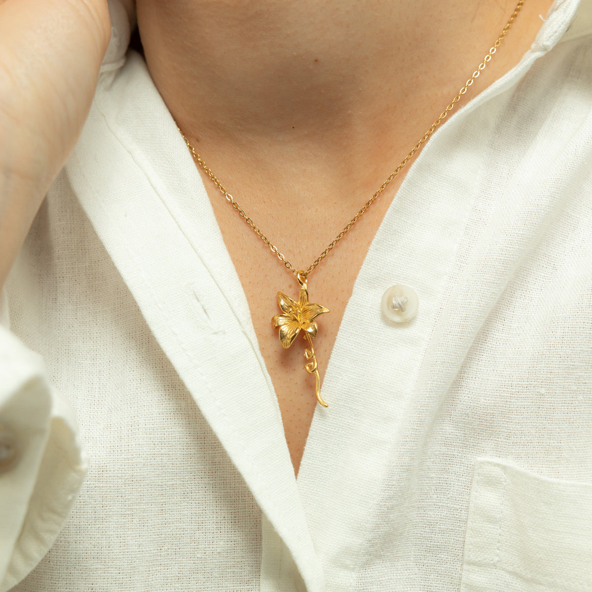 Close up of the gold Passion' Lily Necklace as worn by the model.