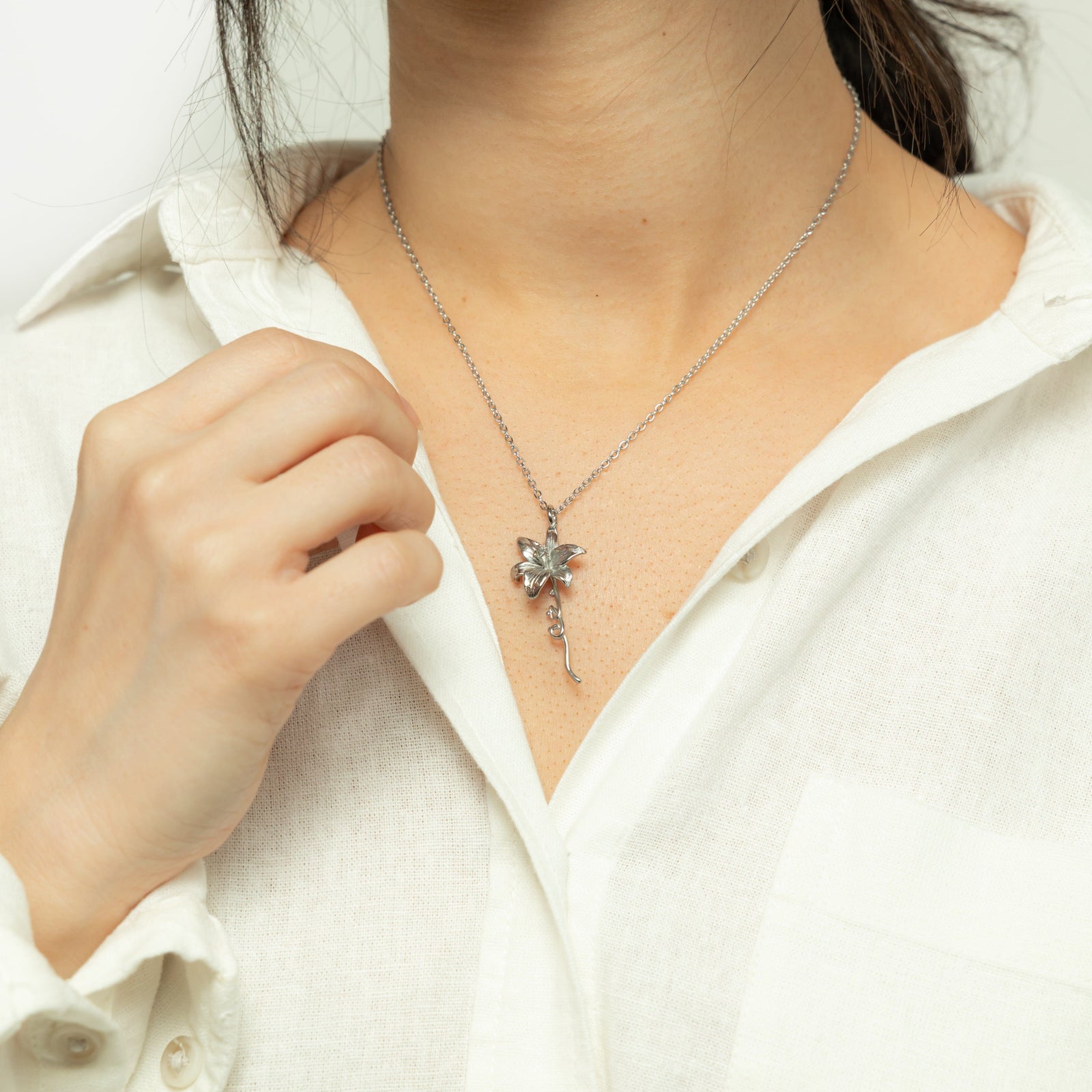 Close up of the silver Passion' Lily Necklace as worn by the model.