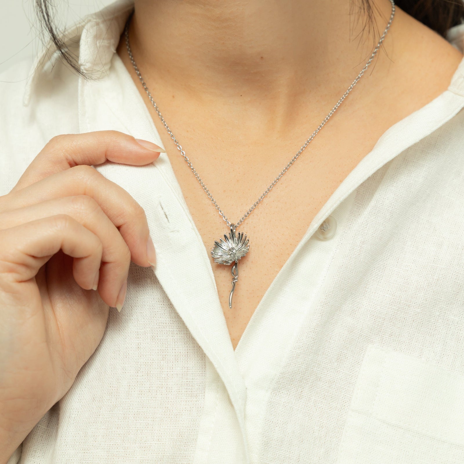 Close up of the silver Patience' Aster Necklace as worn by the model.