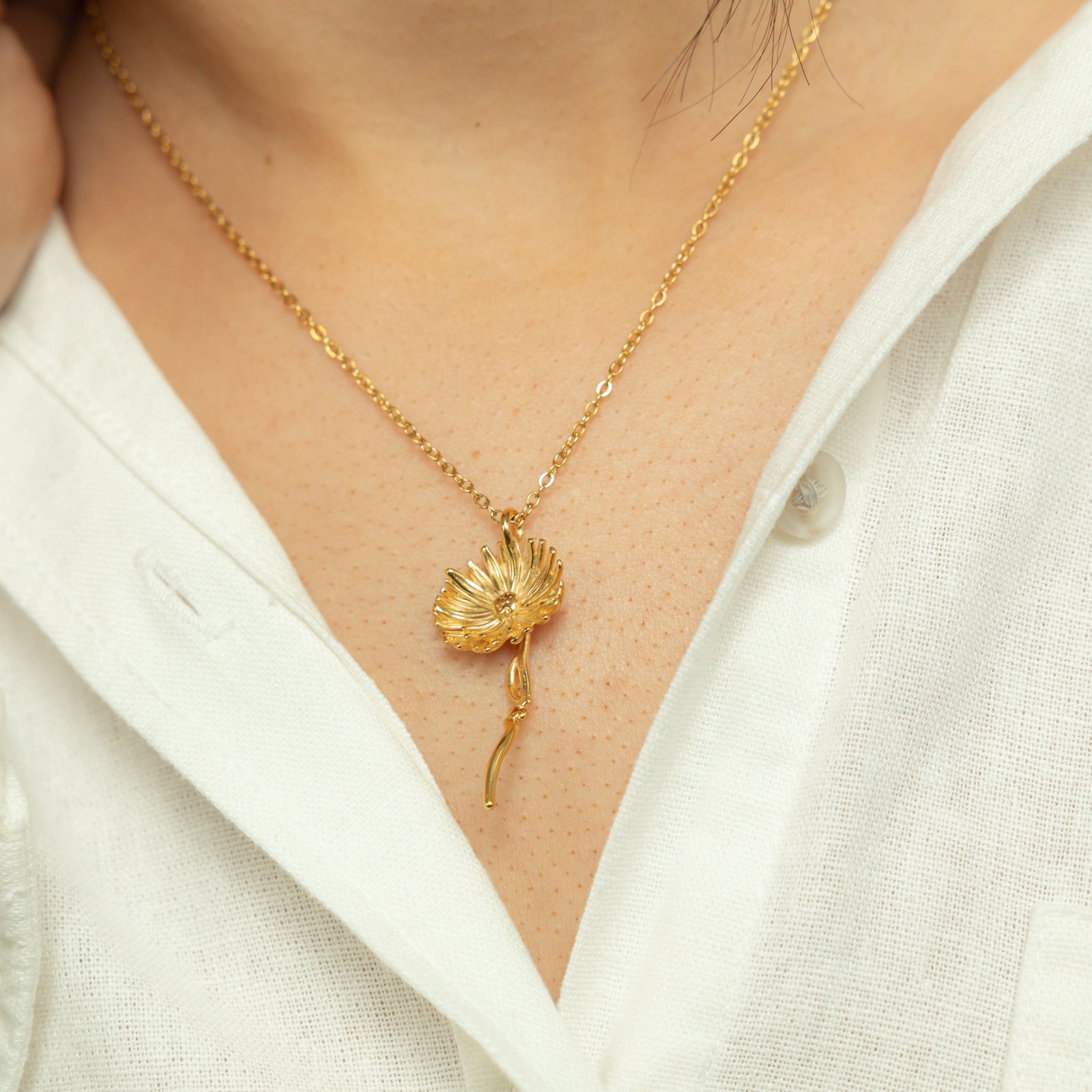 Close up of the gold Patience' Aster Necklace as worn by the model.