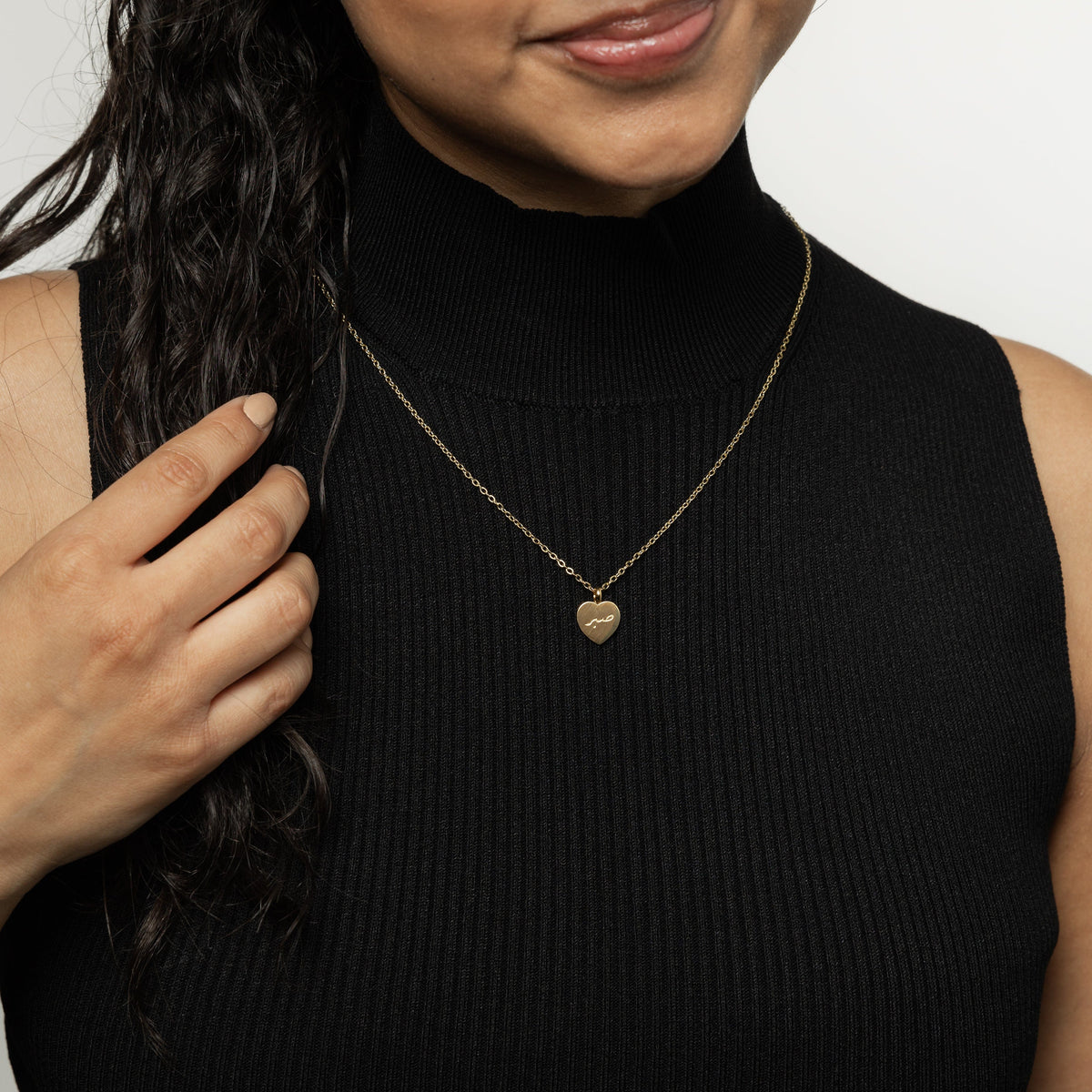 Photo of the model wearing the gold Patience | صبر Charm Necklace.