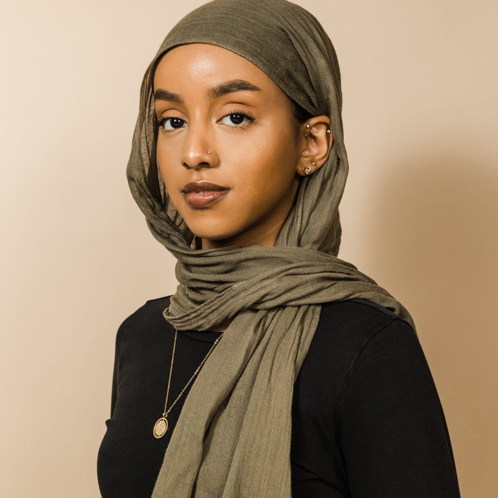 Photo of the model wearing the gold Everything Comes with Patience Necklace.