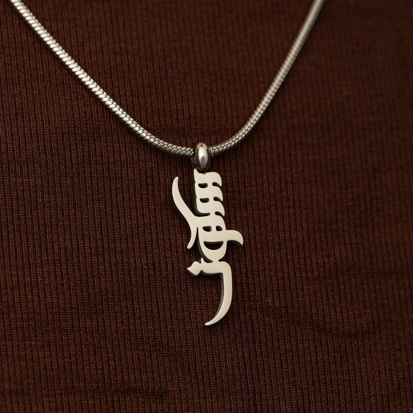 Silver peace of mind necklace on a brown background