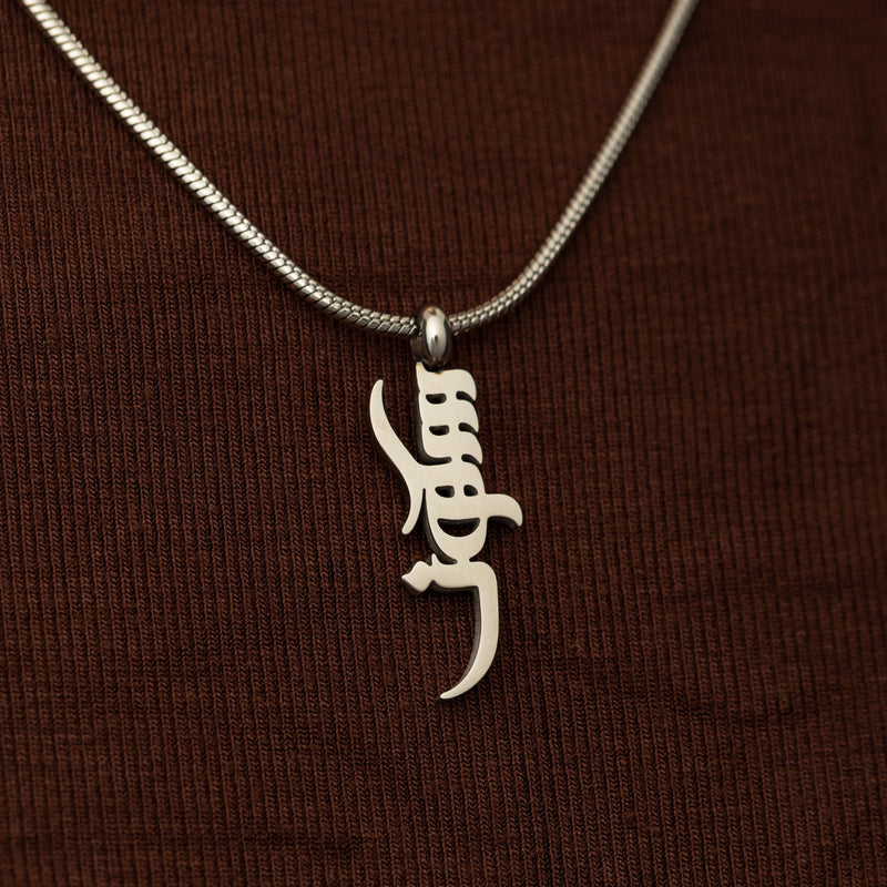 Silver peace of mind necklace on a brown background