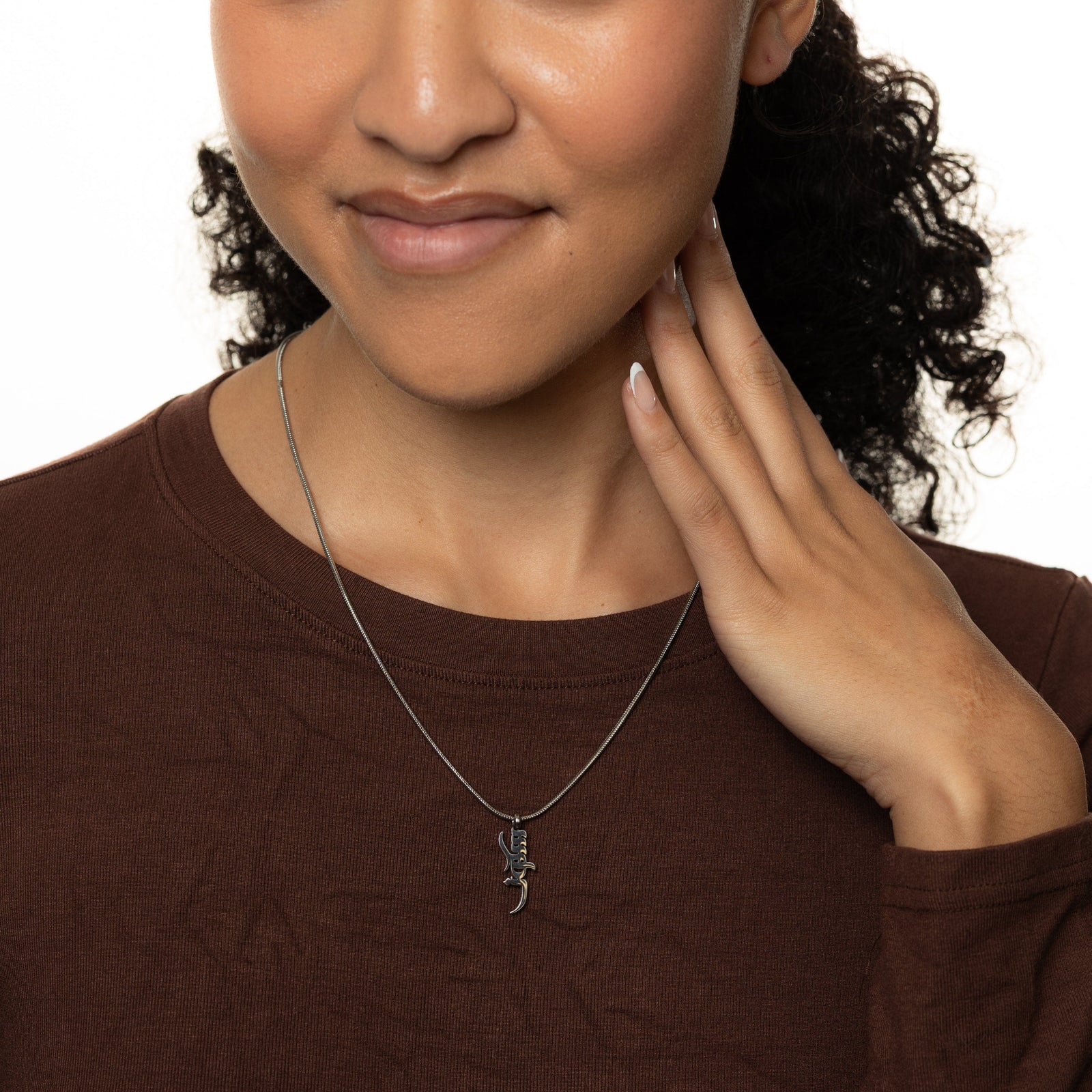 Woman wearing a silver Peace of Mind necklace, with a white background
