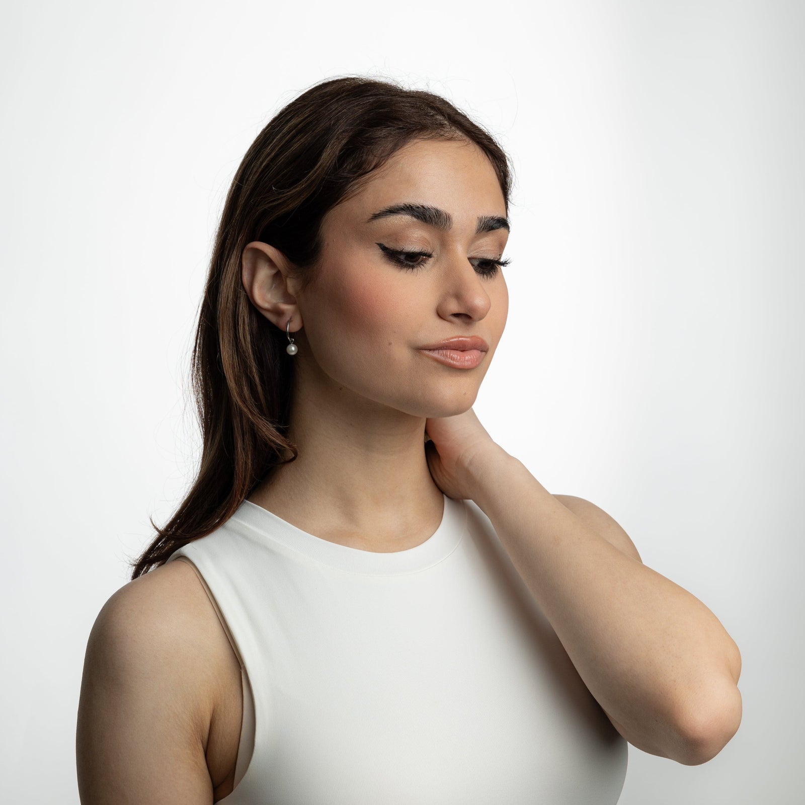 Photo of the model wearing the silver Pearl Hoop Earrings.
