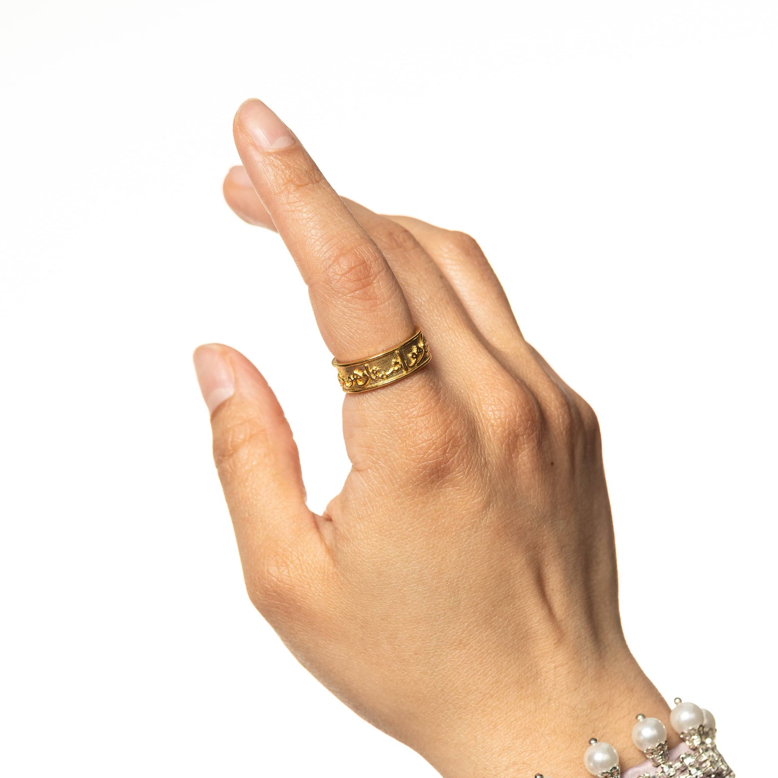 Photo of the model's hand, on the index finger is the gold "Perhaps you dislike what is good for you" Ring.
