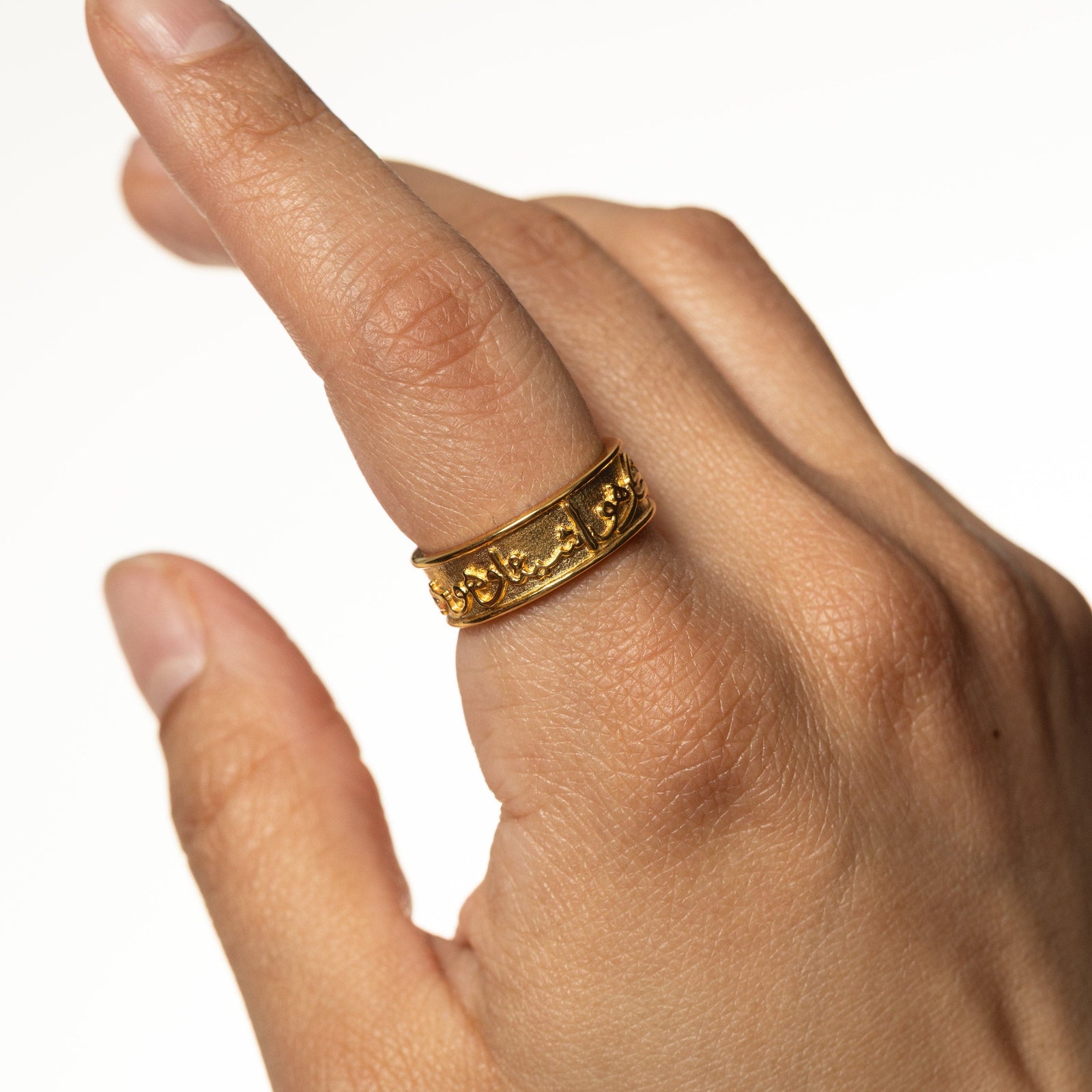 Photo of the model's hand, on the index finger is the gold "Perhaps you dislike what is good for you" Ring.