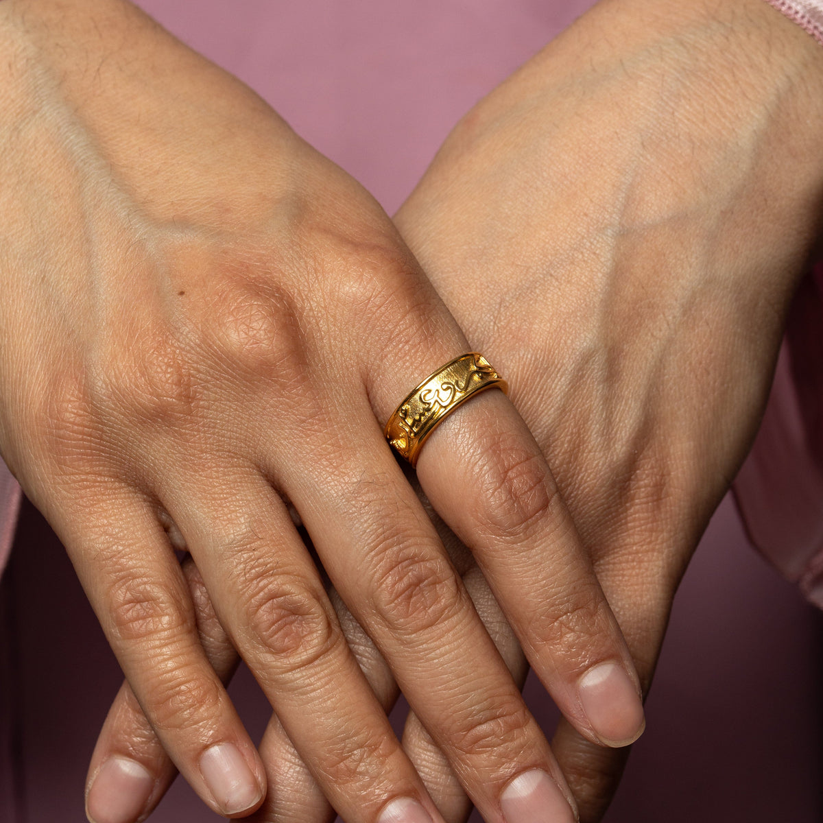 Photo of the model's hand over the other. The model is wearing a gold "Perhaps you dislike what is good for you" Ring on their right index finger.