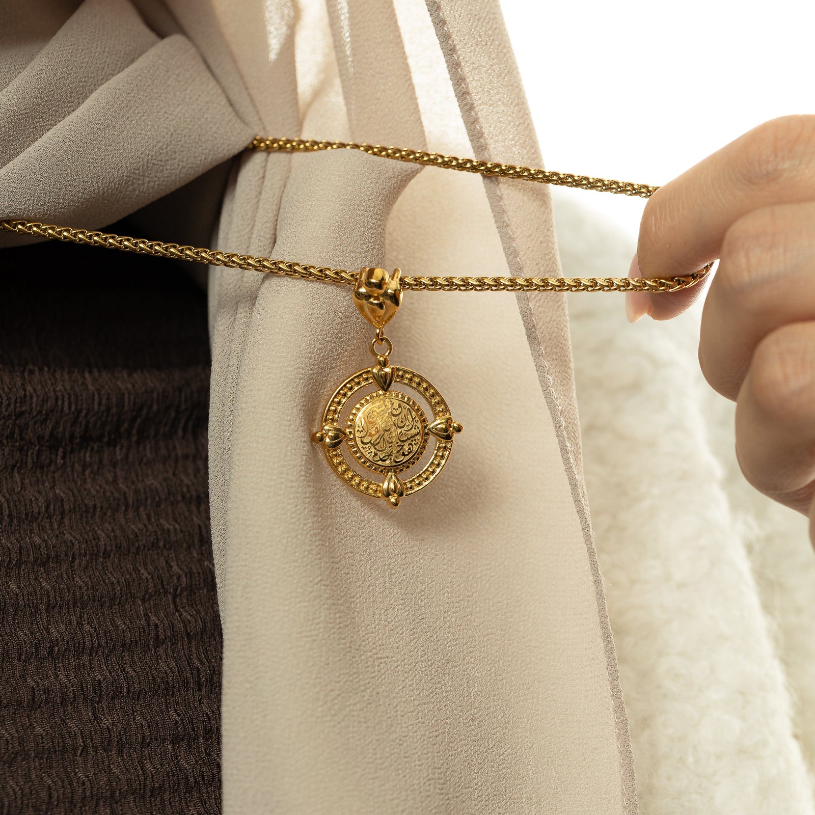 Close-up of the gold “Perhaps you dislike what's good for you” Coin Necklace