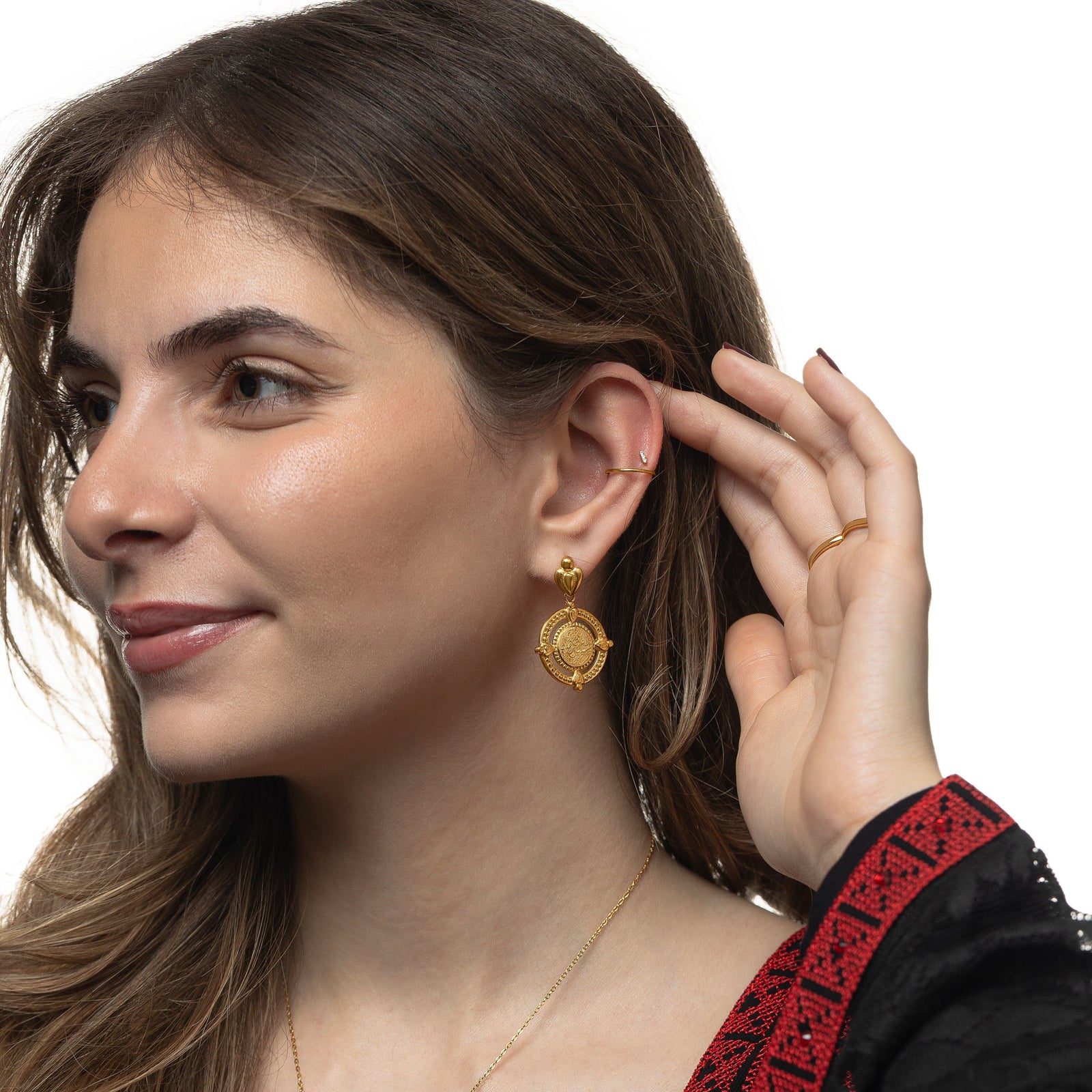 Model touches their left ear with their left fingers. Model is wearing the gold "Perhaps you dislike what's good for you" Coin Earring on their left ear.