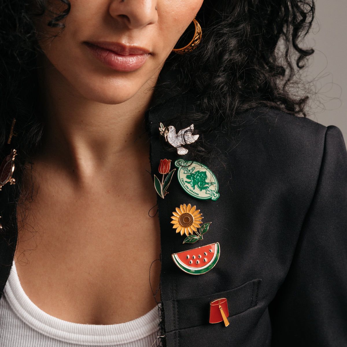 18k gold-plated cultural enamel pins styled on a model's blazer.