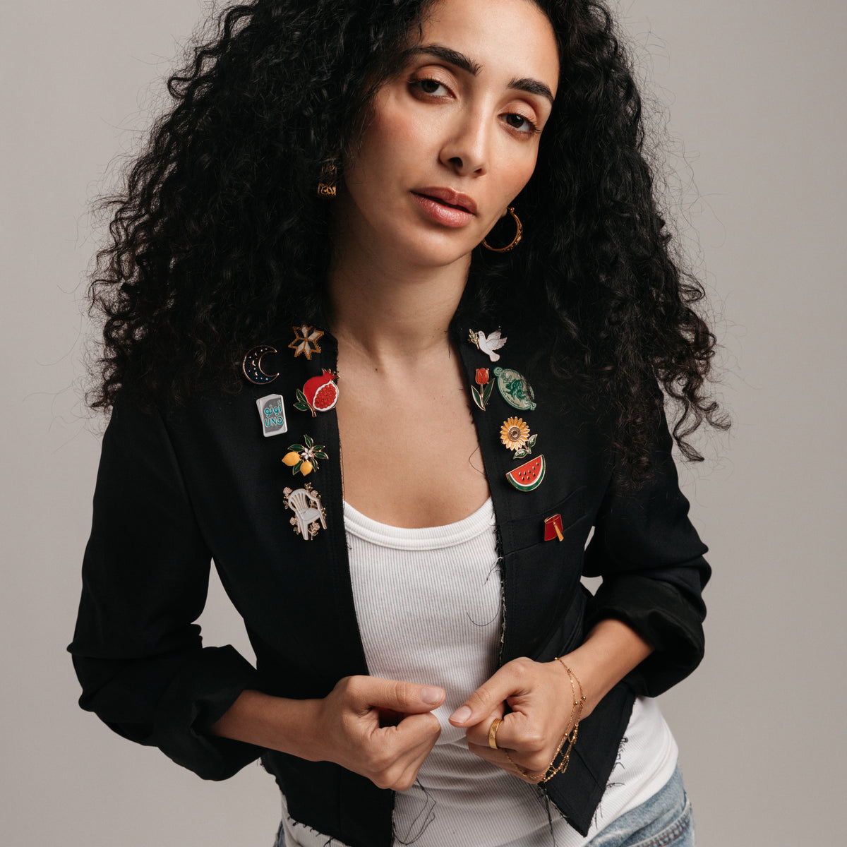 18k gold-plated cultural enamel pins styled on a model's blazer.