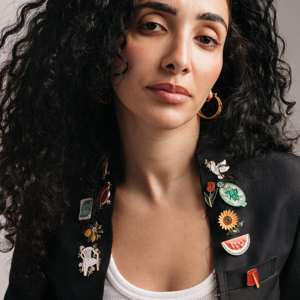 18k gold-plated cultural enamel pins styled on a model's blazer.