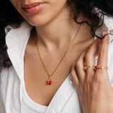 Model styled in 18k gold-plated Nominal jewelry featuring the Pomegranate Necklace paired with the Pomegranate Vine Ring and Rose Ring.