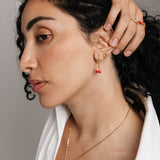 Model styled in 18k gold-plated Nominal jewelry featuring the Pomegranate Vine Earrings, Rose Studs, and Pomegranate Vine Ring.