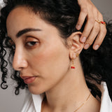 Model styled in 18k gold-plated Nominal jewelry featuring the Pomegranate Vine Earrings, Rose Studs, and Pomegranate Vine Ring.