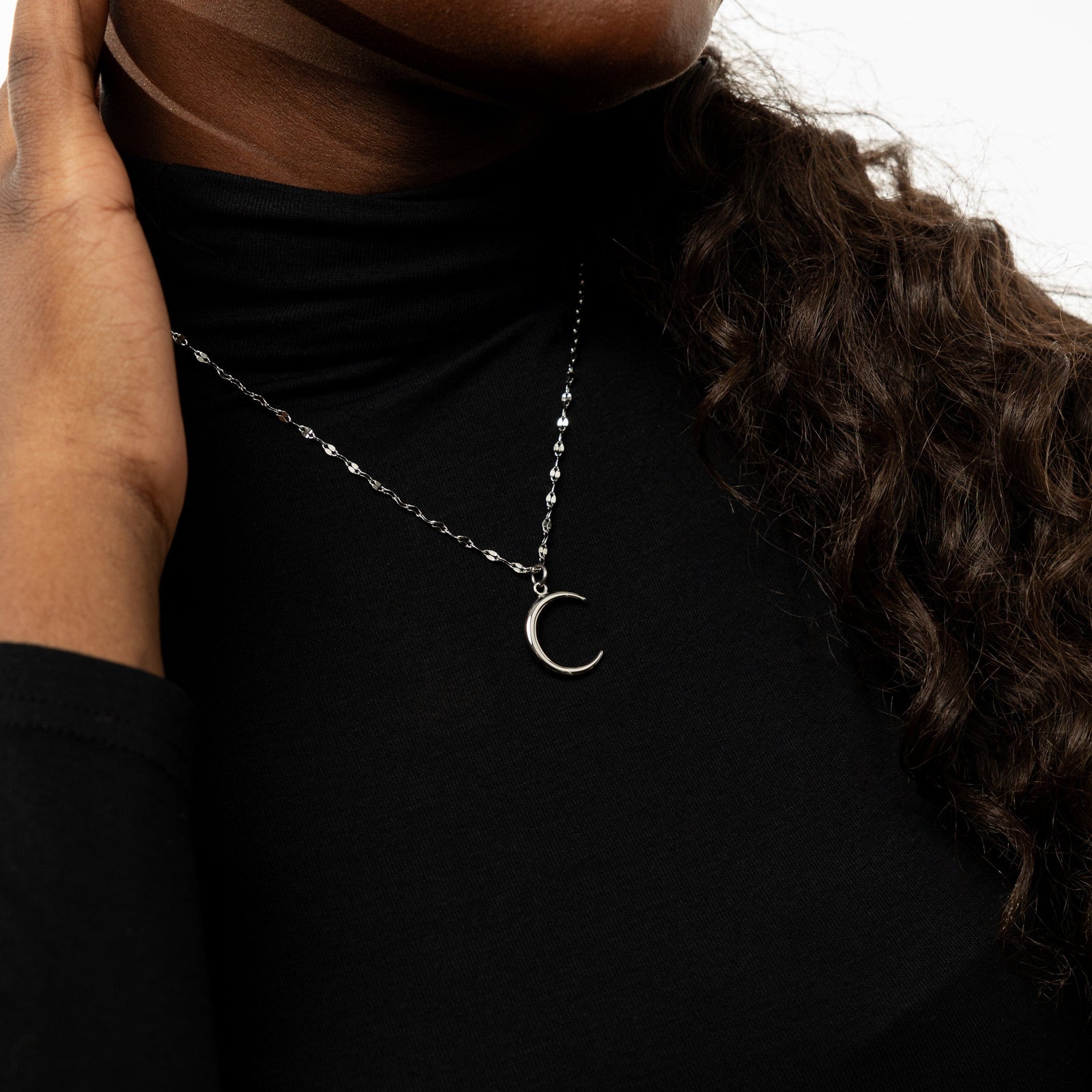 Close up of the silver Premium Crescent Necklace as worn by the model.