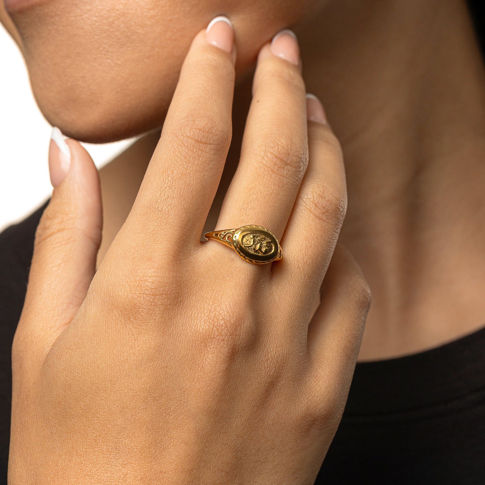 Hand wearing the gold Qadr | Destiny Ring, showing the oval engraved face and side detailing.