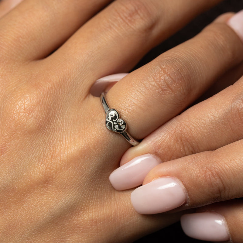 Close-up of a hand wearing a silver Quwa | Strength Heart ring