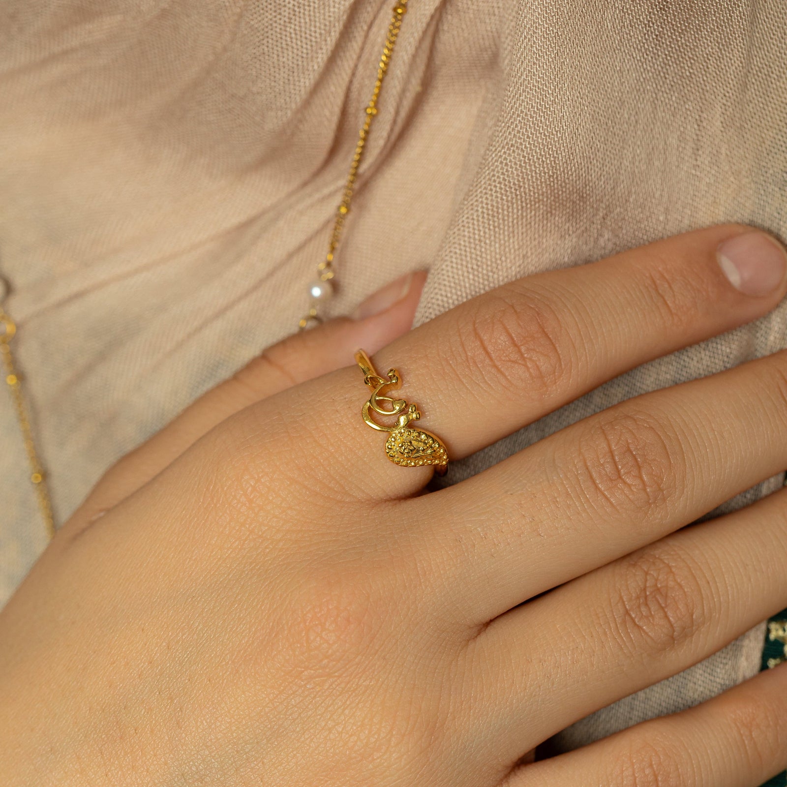 Photo of the model's hand wearing the gold Quwa | Strength Paisley Ring.