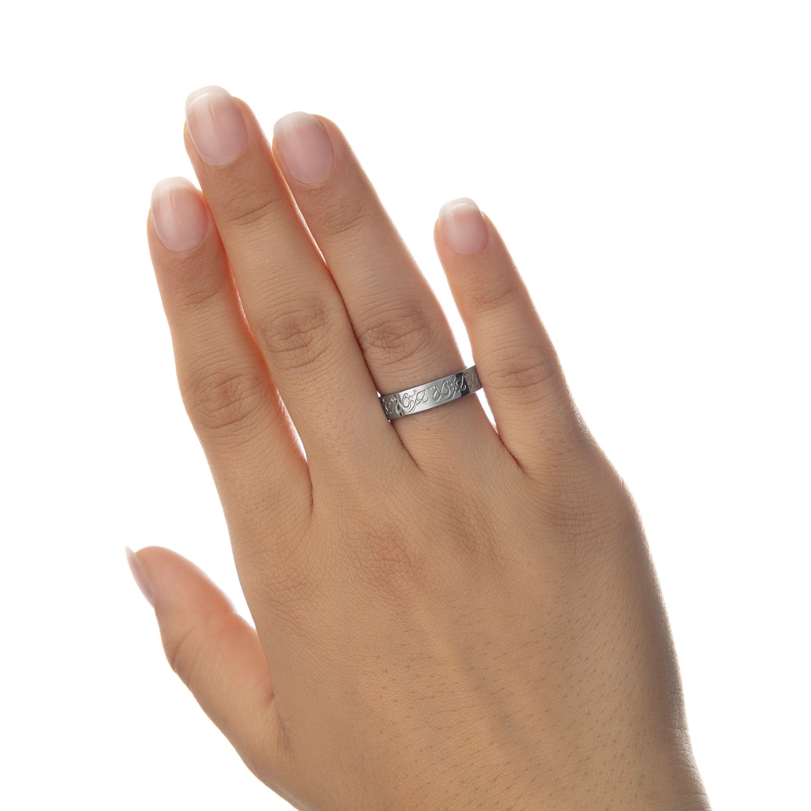 Woman’s hand extended with silver Rahma Mercy Ring on her ring finger, Arabic calligraphy visible, background in soft white lighting.