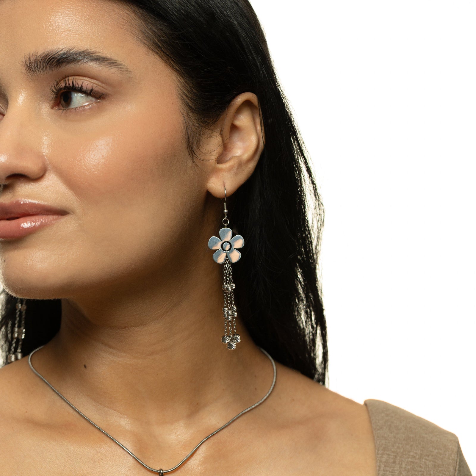 Woman wearing the silver Raining Flower Earrings, styled with straight dark hair and silver floral necklace for a coordinated look.