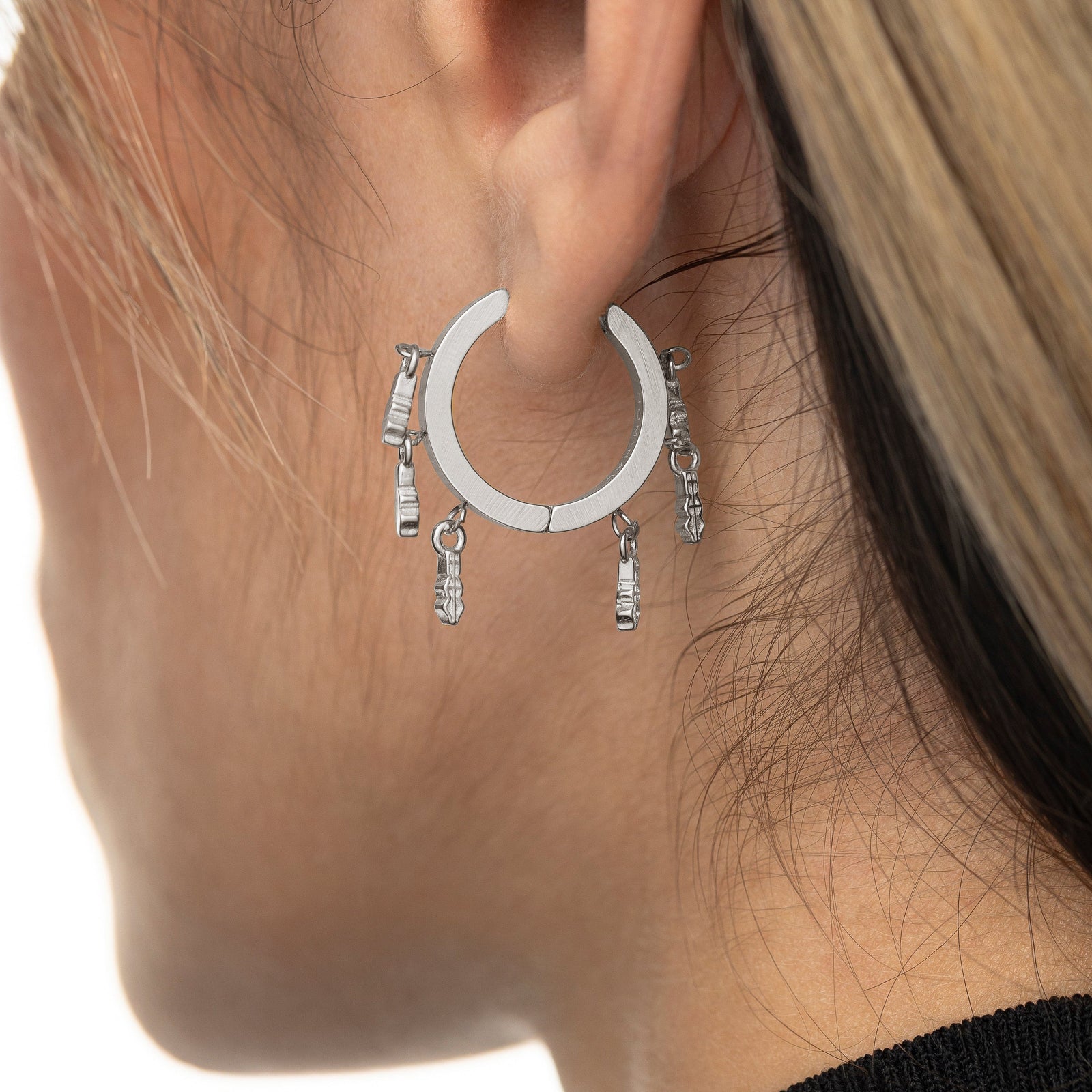 Close up of the silver Raining Tatreez Hoop Earrings on the model's left ear.