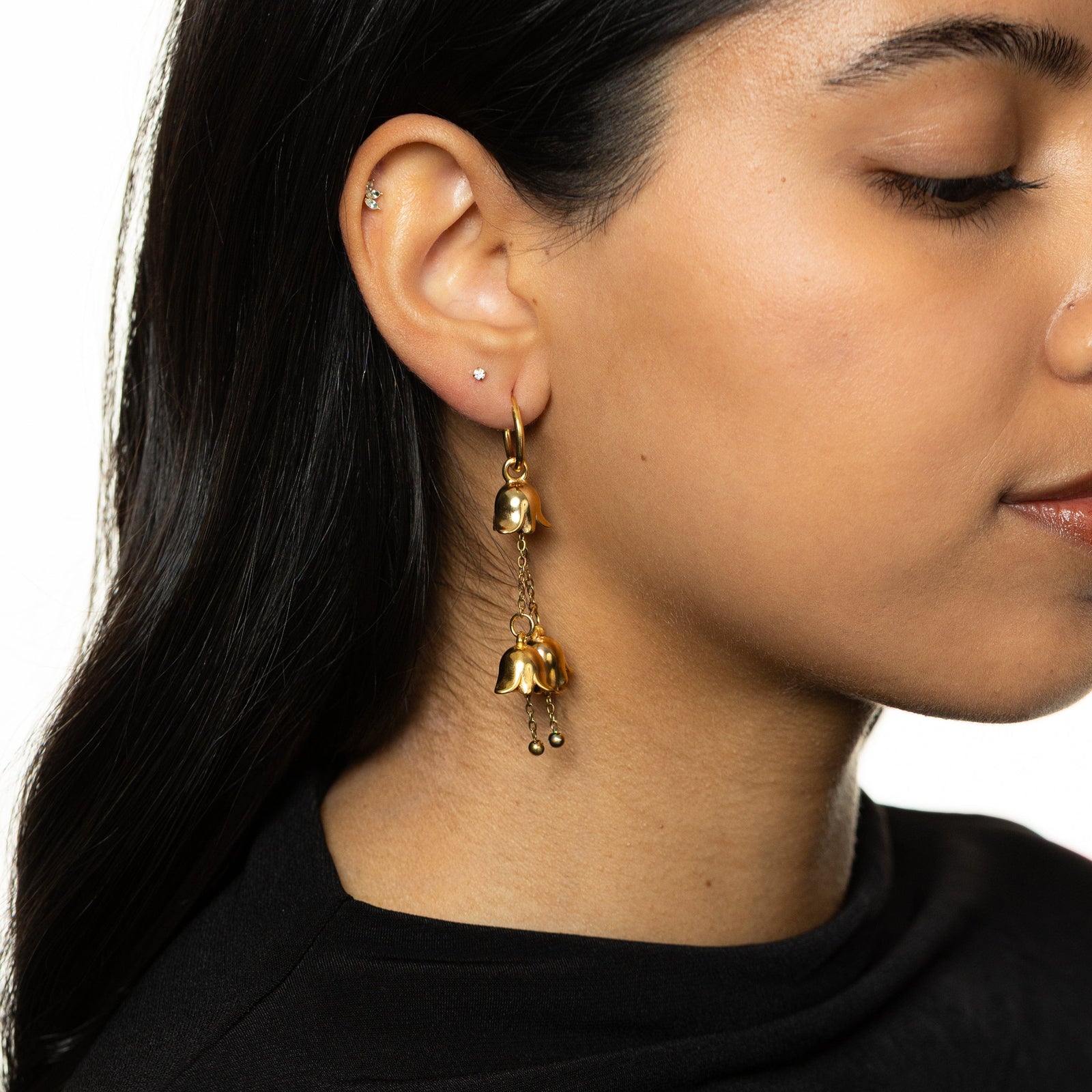 Gold Raining Tulip Hoops styled on-ear, showing the floral charms.
