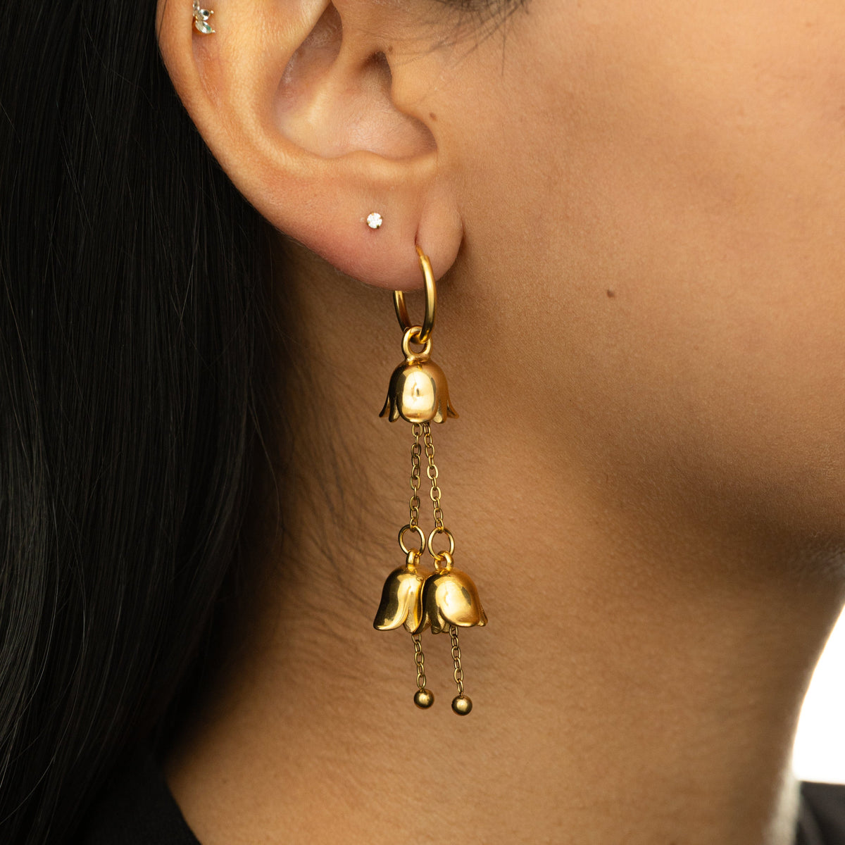 Gold Raining Tulip Hoops styled on-ear, showing the floral charms.