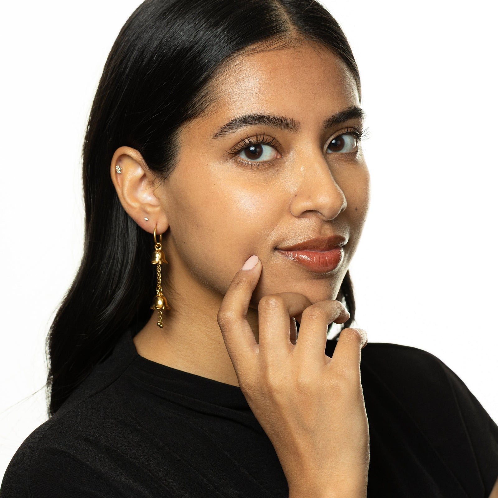 Model wearing the gold Raining Tulip Hoops, styled with a black top.