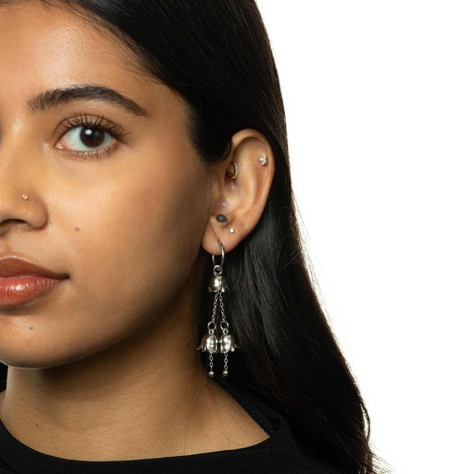 Model wearing the silver Raining Tulip Hoops, styled with a black top.