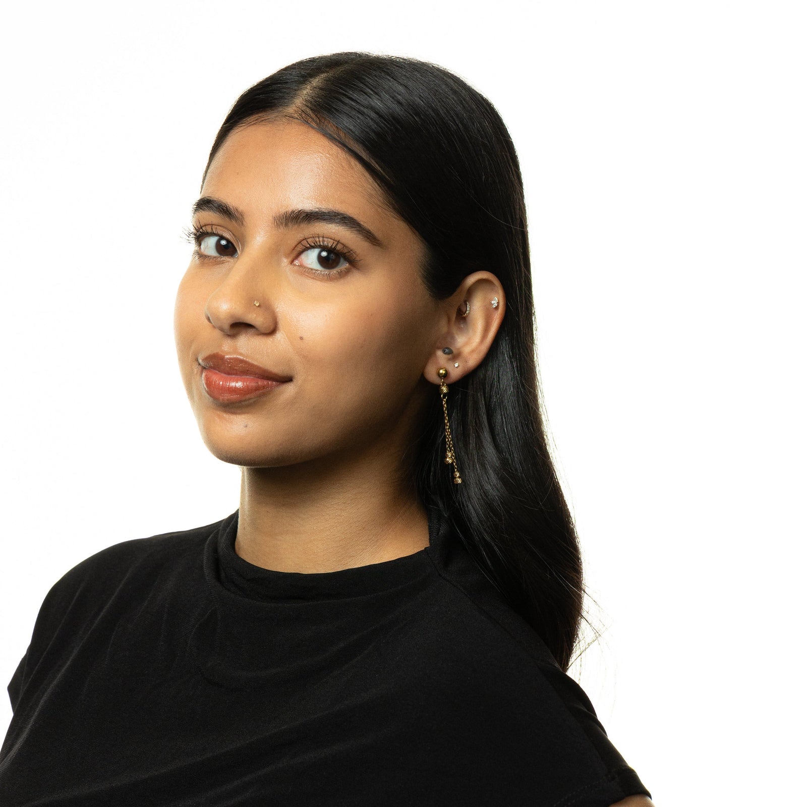 Woman wearing gold Raining Earrings styled with a black high-neck top