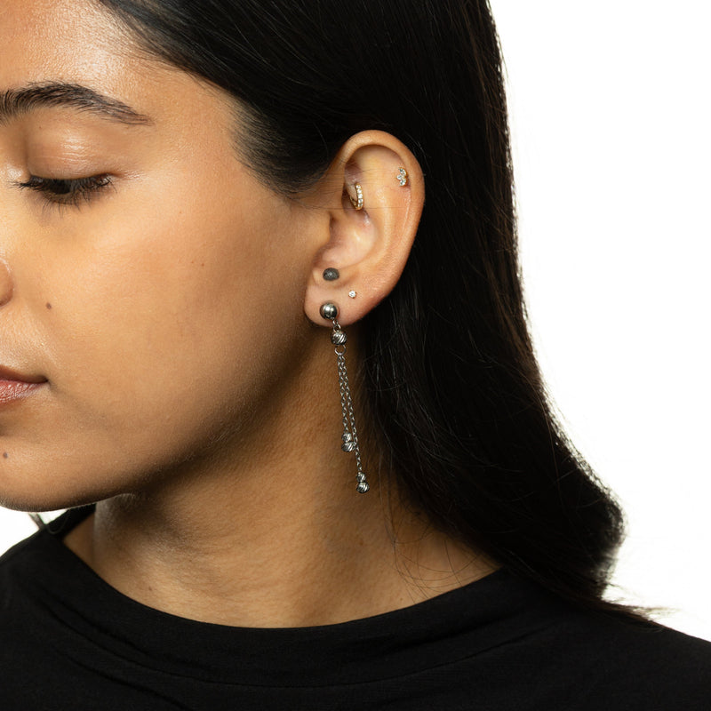 Woman wearing silver Raining Earrings with dual chains and ribbed beads.