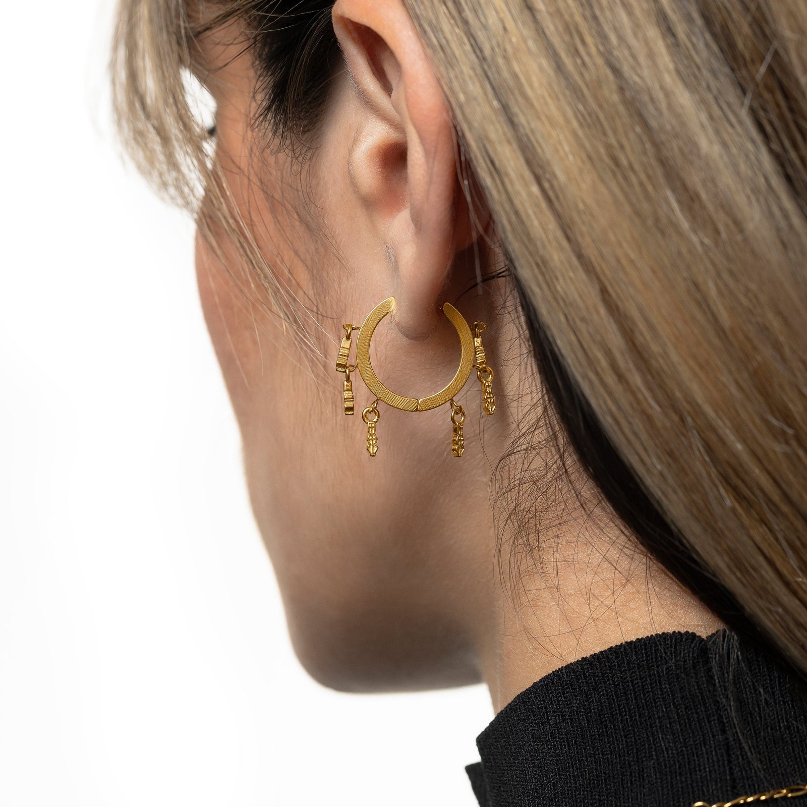 Close up of the gold Raining Tatreez Hoop Earrings on the model's left ear.