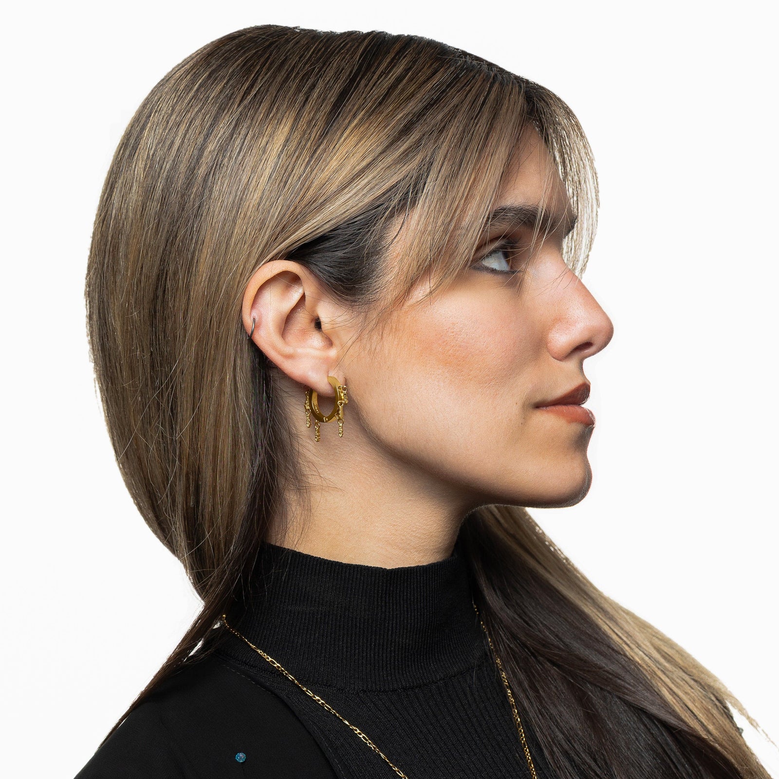 Photo of the model wearing the gold Raining Tatreez Hoop Earrings.