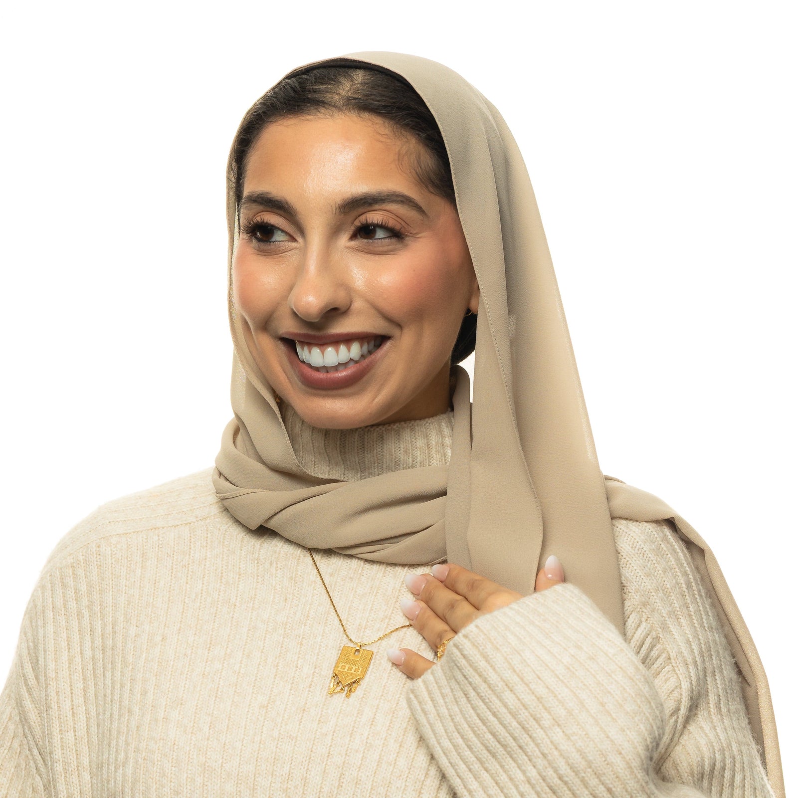 Model wearing the Raining Tatreez Necklace over a cream ribbed sweater and beige hijab