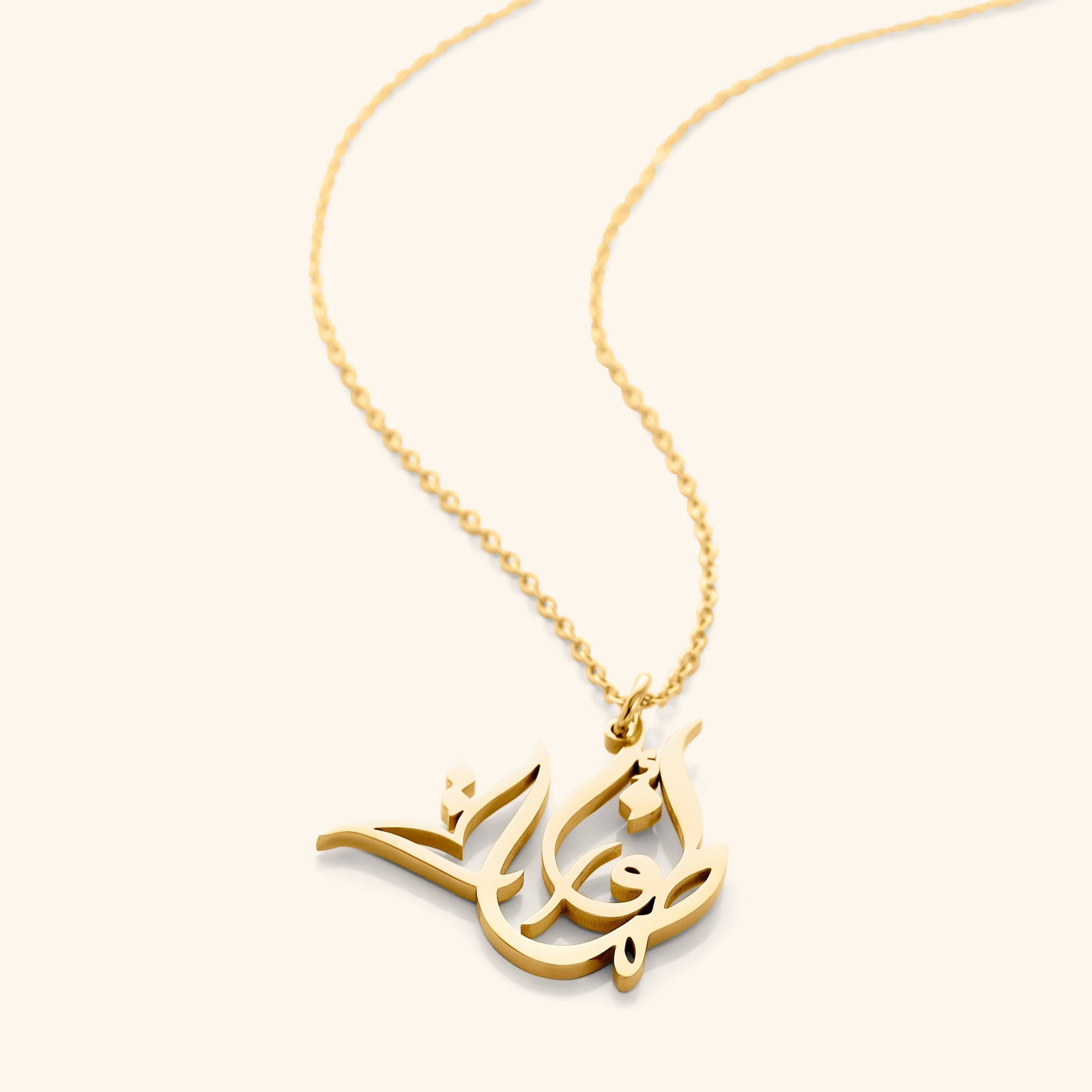 The 18k gold plated Ready Name Necklace | Calligraphy laid flat against a light background.