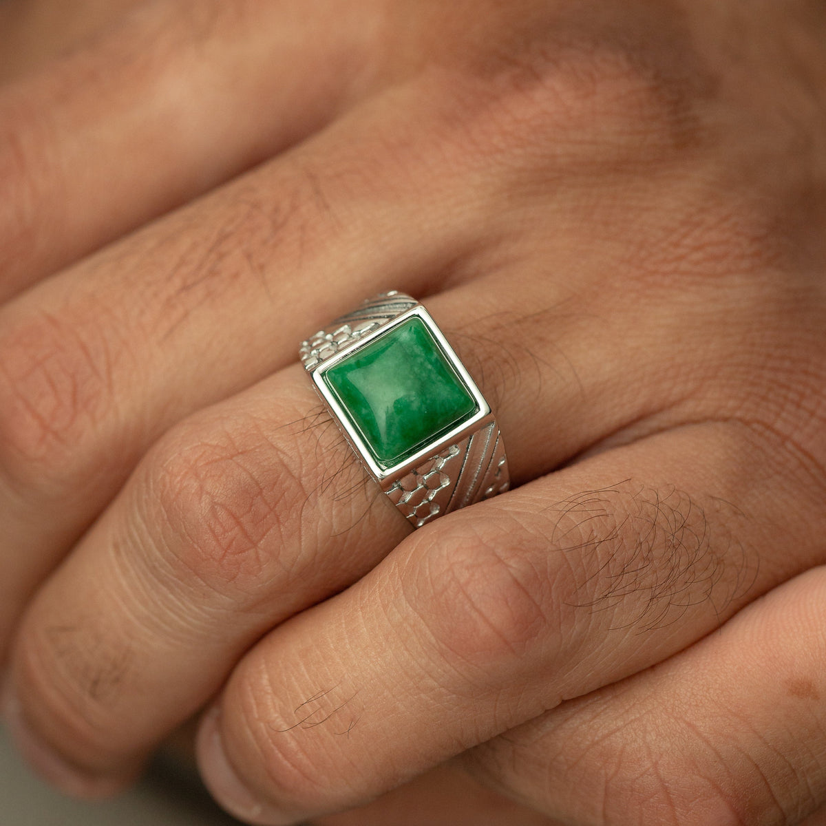 Man wearing the ‘River to Sea’ Onyx Ring | Men, showing the green onyx stone and engraved silver band.